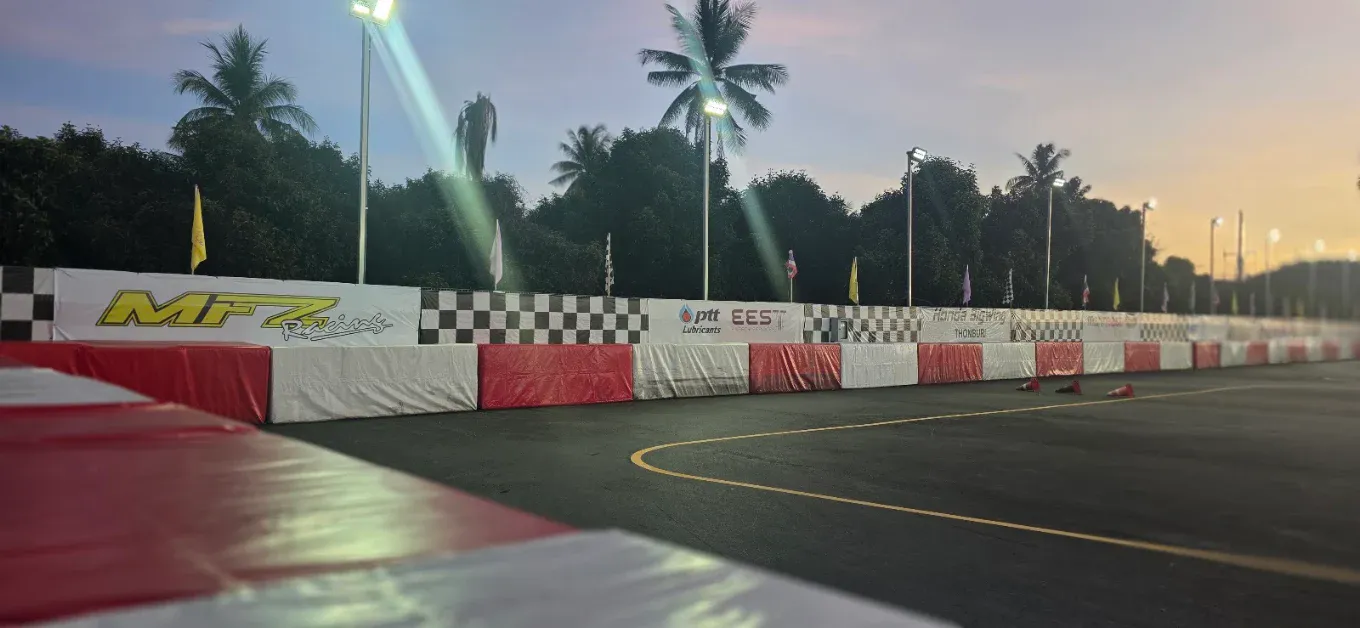The sponsor wall along the mini-circuit barriers at dusk
