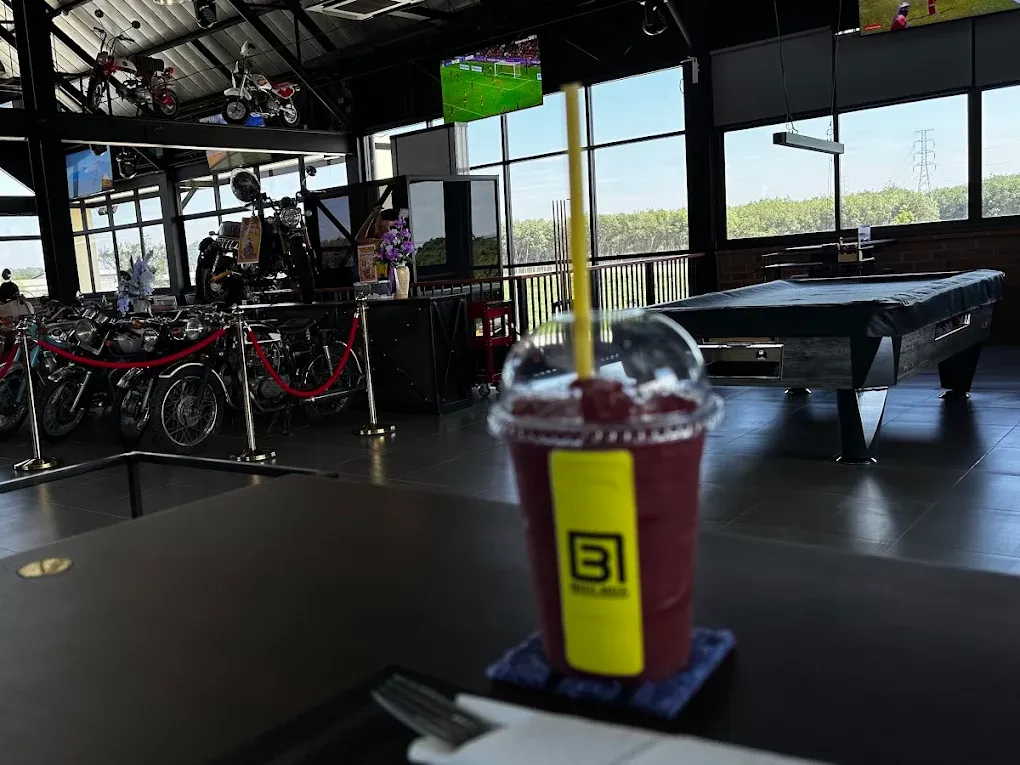 A BOX BOX smoothie on the bar table, pool table and gallery bikes behind
