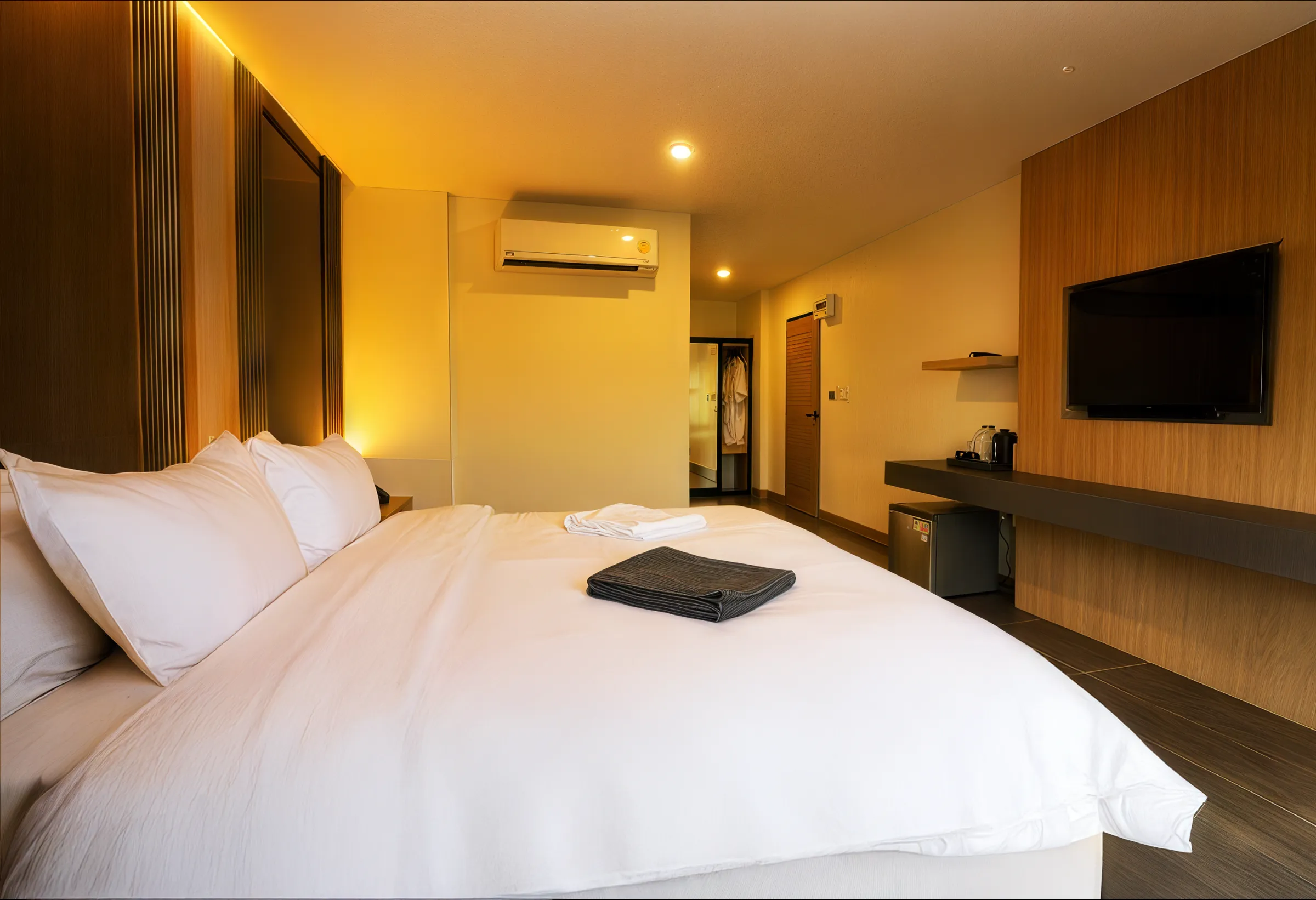 A warmly-lit king room at Box Box Hotel